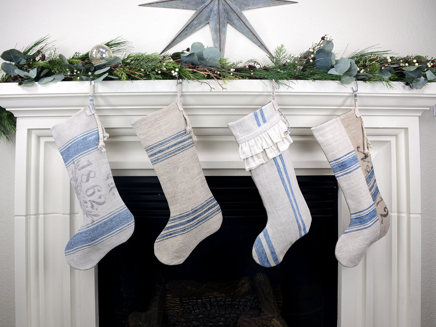 Group of four Christmas stockings hanging on fireplace