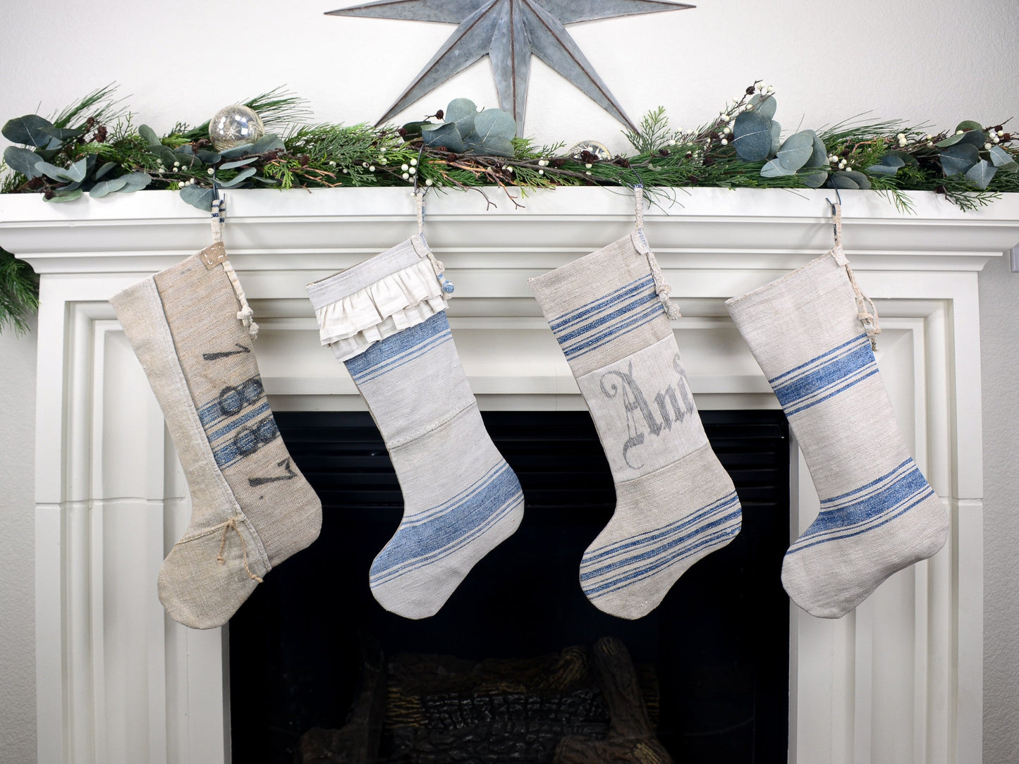 Group of four Christmas stockings hanging on fireplace