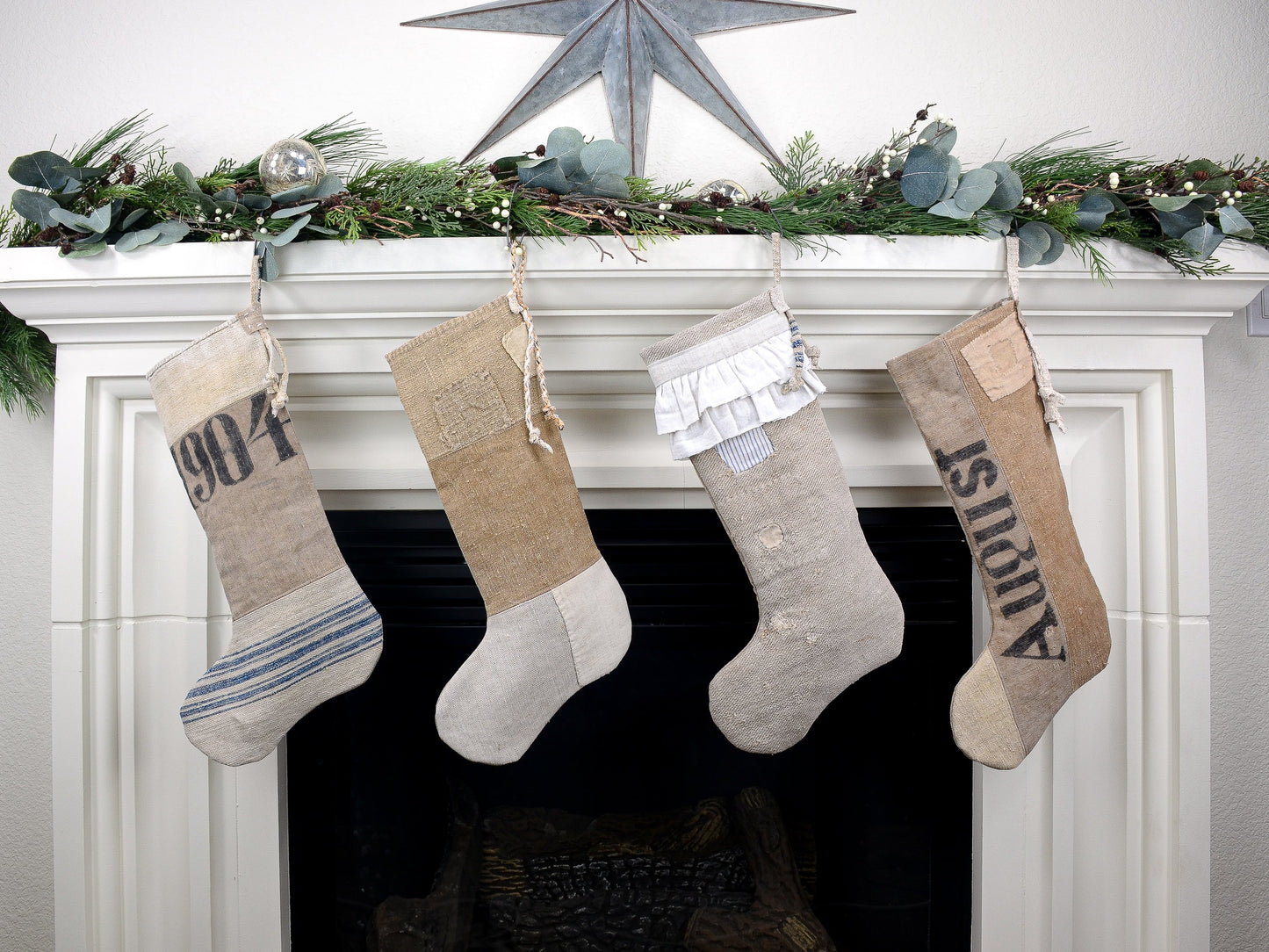 Group of four Christmas stockings hanging on fireplace