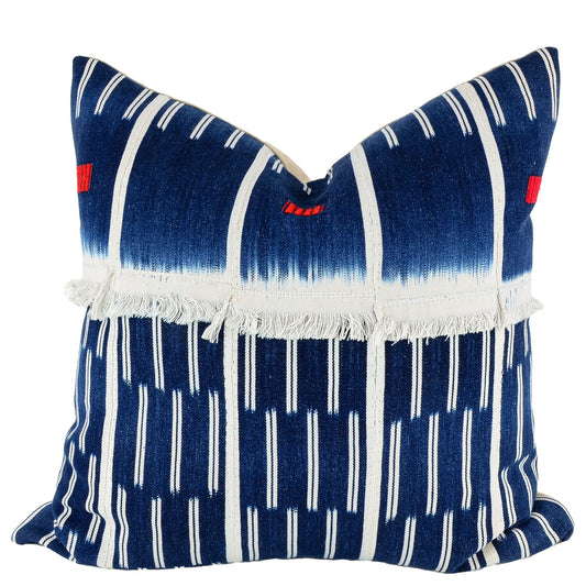 Front of pillow with rich blue patterns, white stripes and white fringe made from vintage handwoven Baoulé/Baule cotton cloth from Africa's Ivory Coast, reflecting the traditions, symbols, and tribal lives of the Baoulé/Baule people