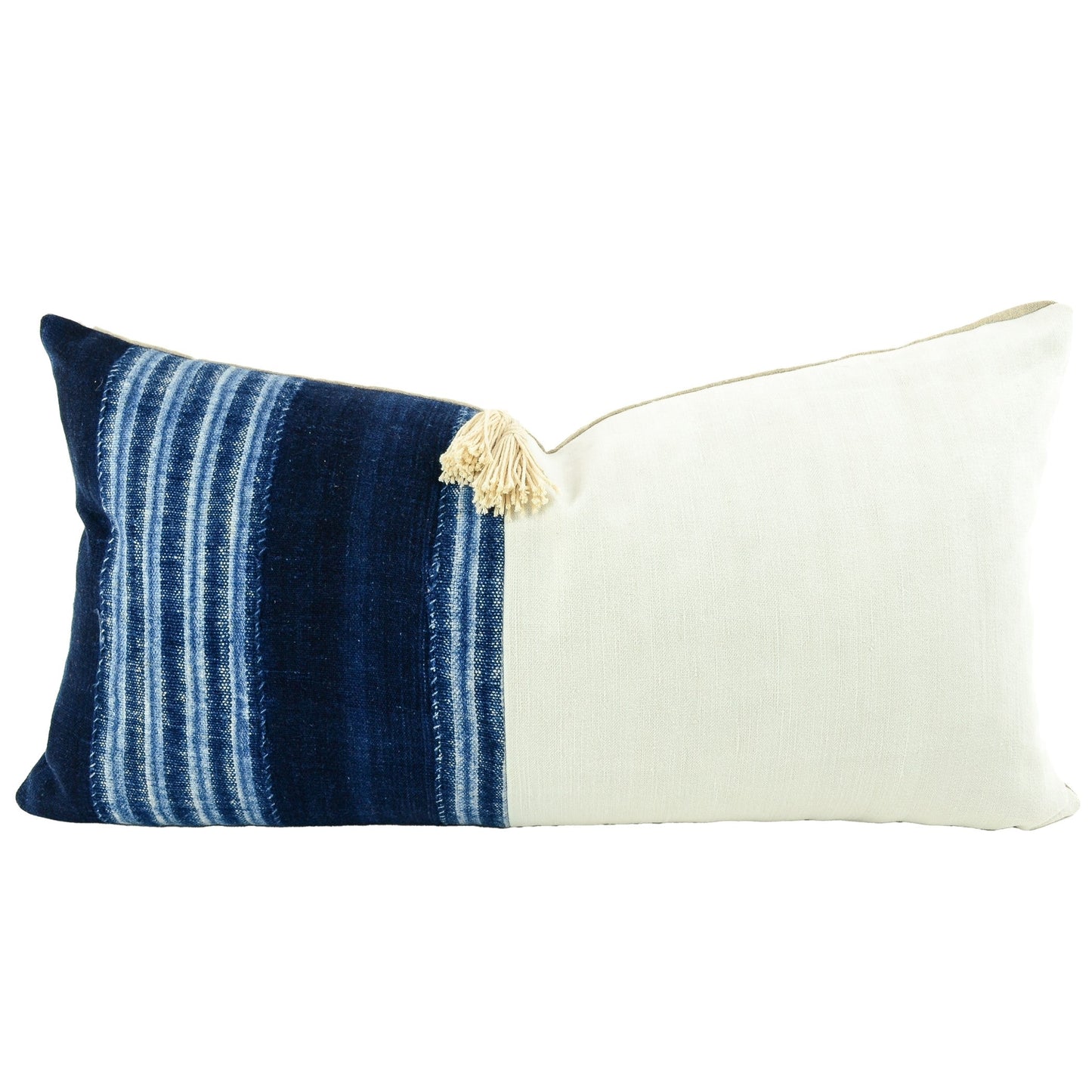 Front of pillow with rich blue and white patterns made from a traditional handwoven indigo cloth from Mali West Africa, vintage white European linen and an off-white tassle in the upper middle of the pillow