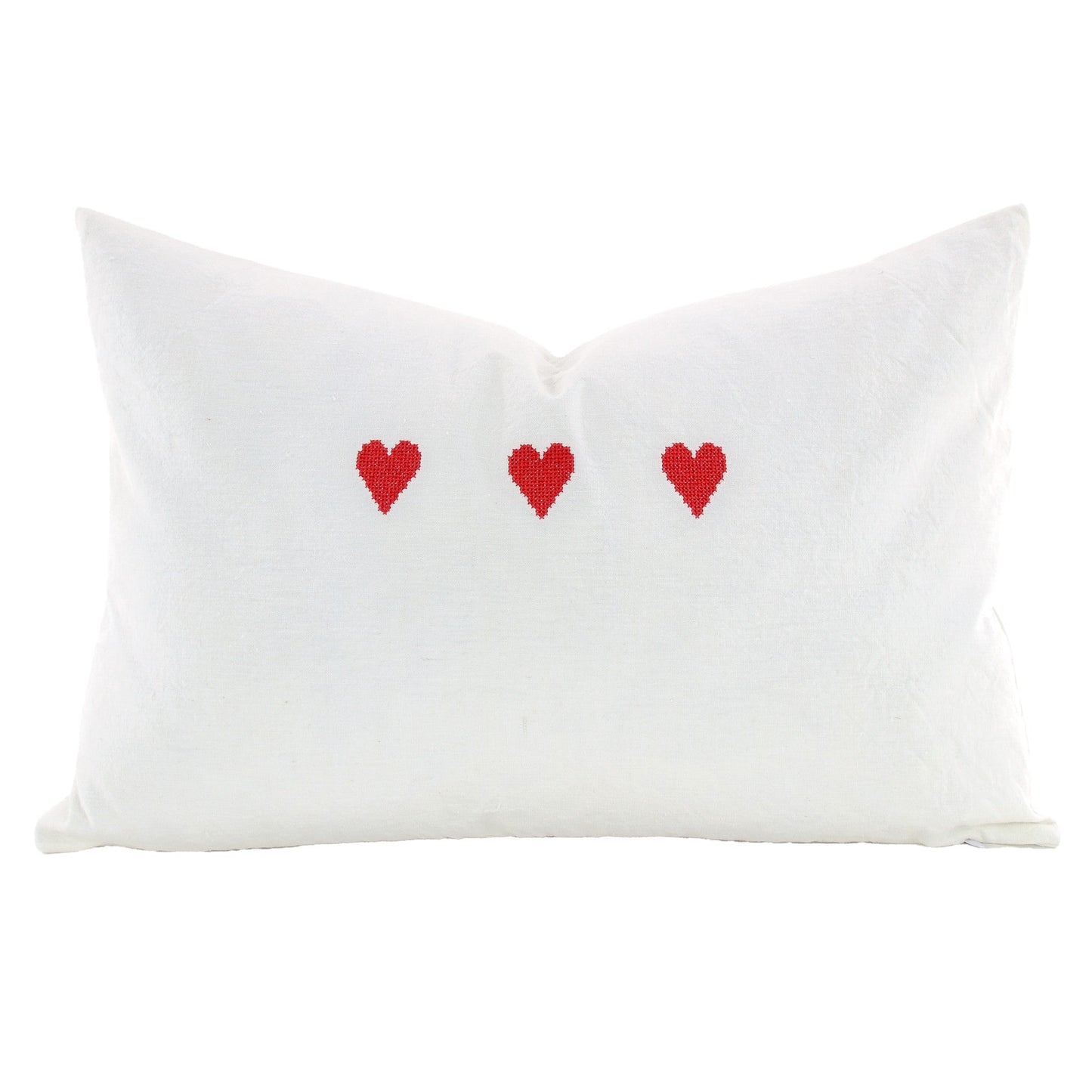 Front of pillow made from vintage European white linen and embroidered with three red hearts