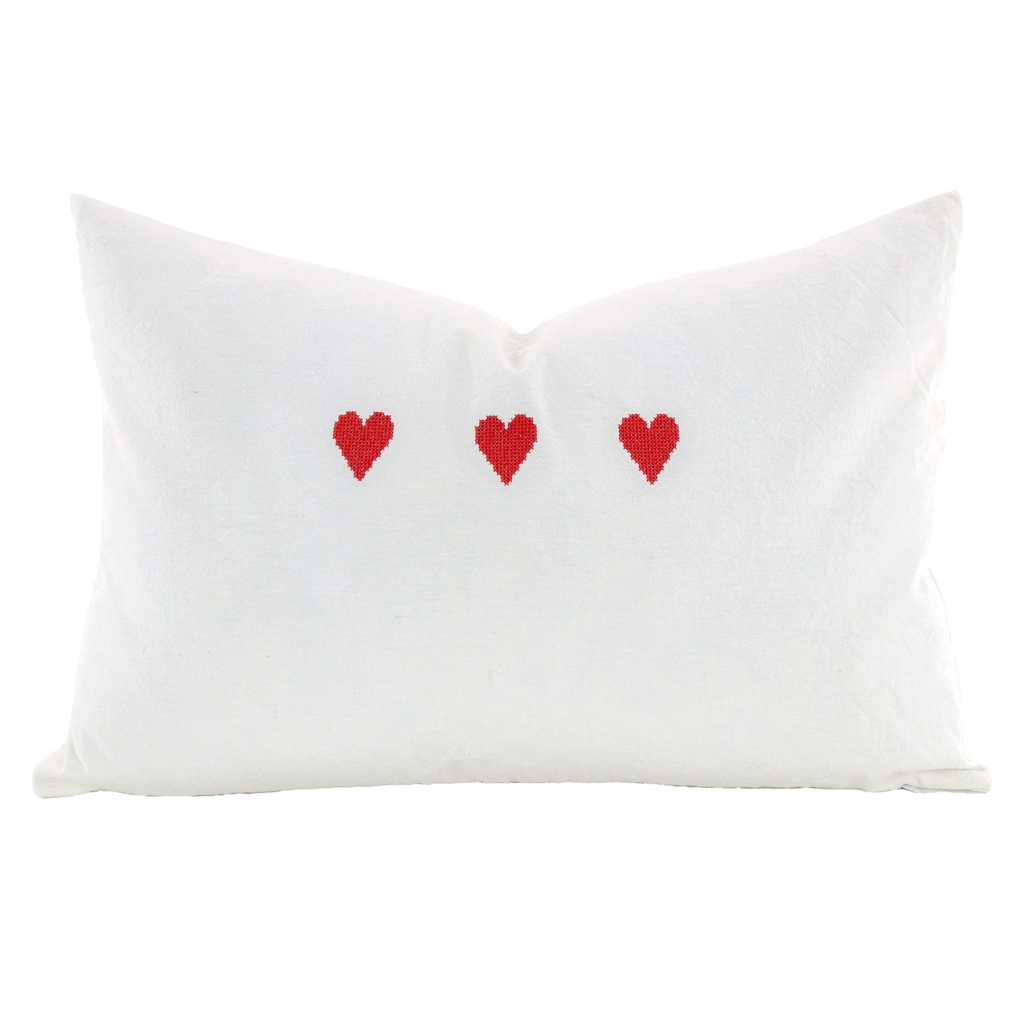 Front of pillow made from vintage European white linen and embroidered with three red hearts
