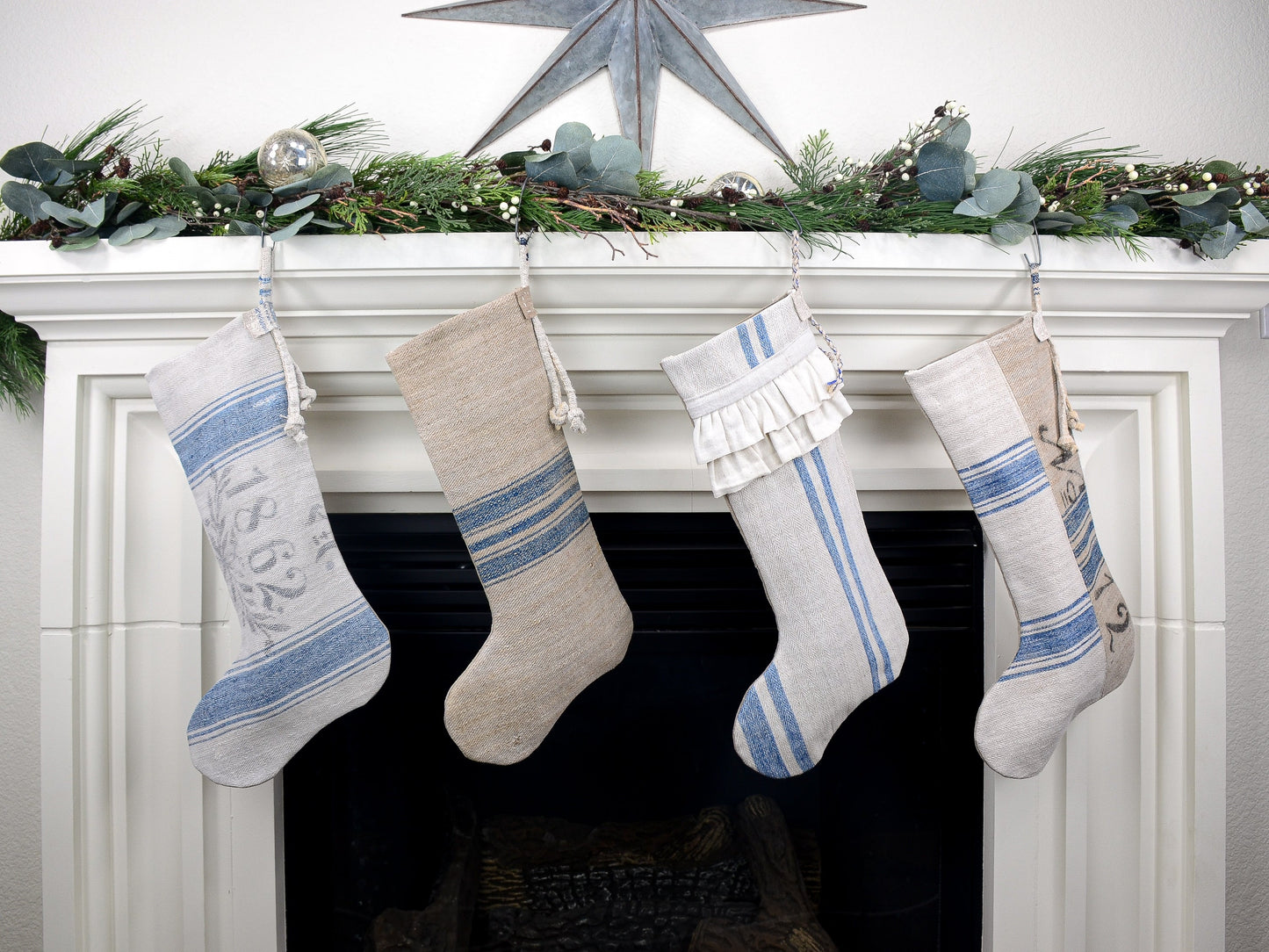 Group of four Christmas stockings hanging on fireplace