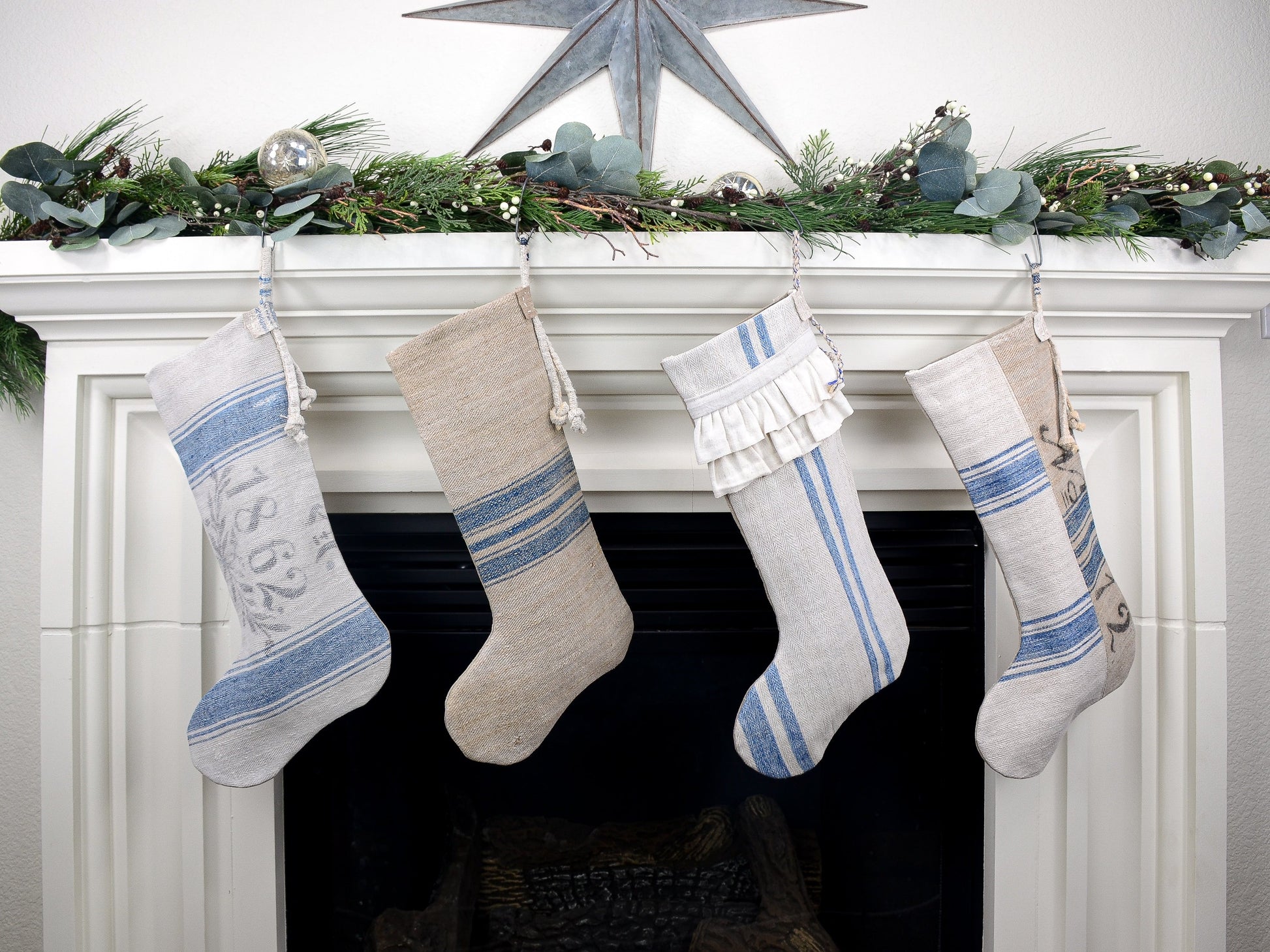 Group of four Christmas stockings hanging on fireplace