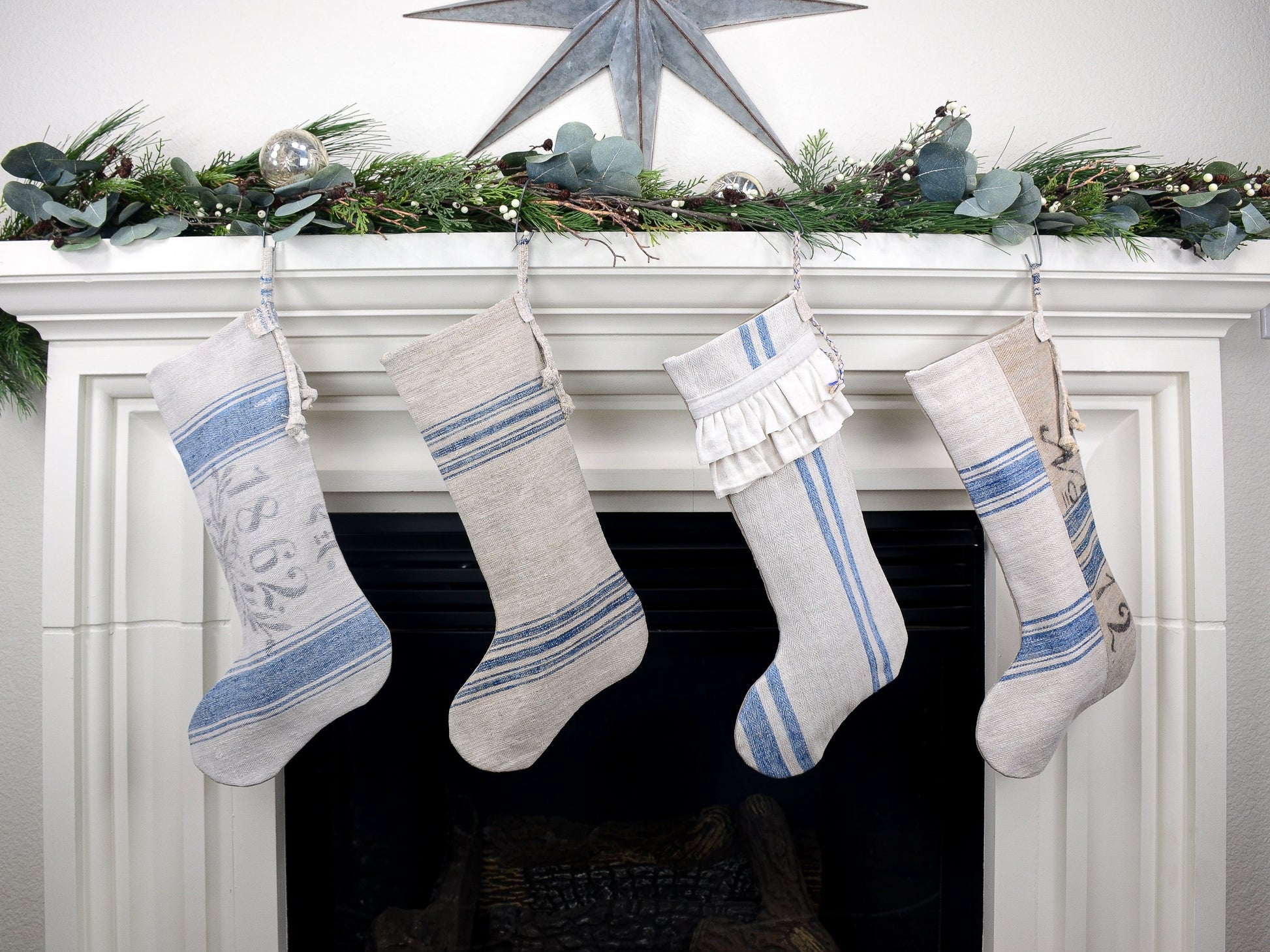 Group of four Christmas stockings hanging on fireplace