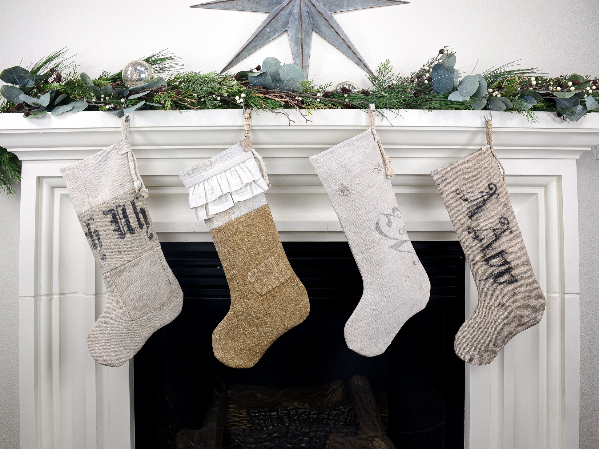 Group of four Christmas stockings hanging on fireplace