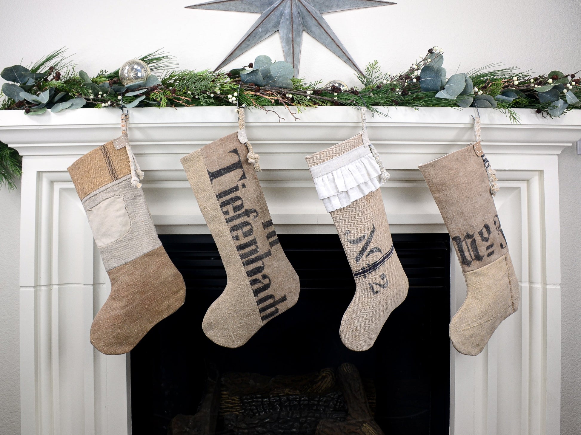 Group of four Christmas stockings hanging on fireplace