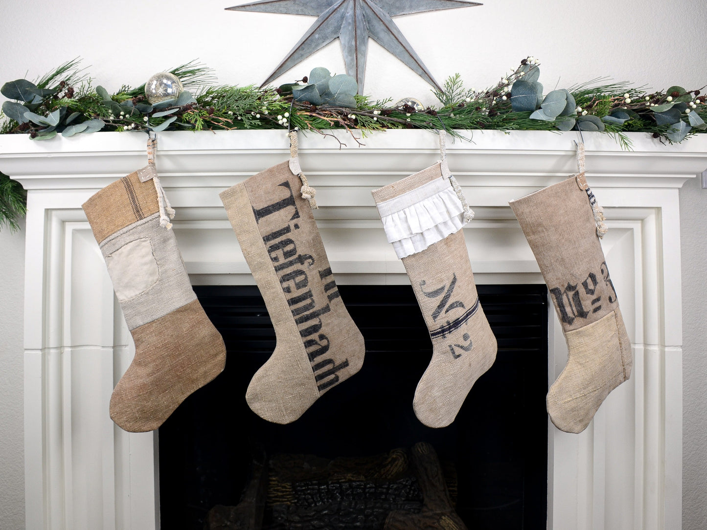 Group of four Christmas stockings hanging on fireplace