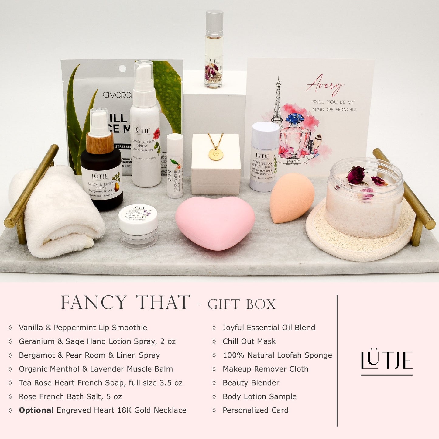 Fancy That Gift Box for women, BFF, wife, daughter, sister, mom, or grandma, includes Geranium & Sage hand lotion spray, essential oil, lip balm, soothing muscle balm, Bergamot & Pear room & linen spray, French soap, French bath salts, hydrating face mask, other bath, spa and self-care items, and 18K gold-plated necklace with engraved heart.