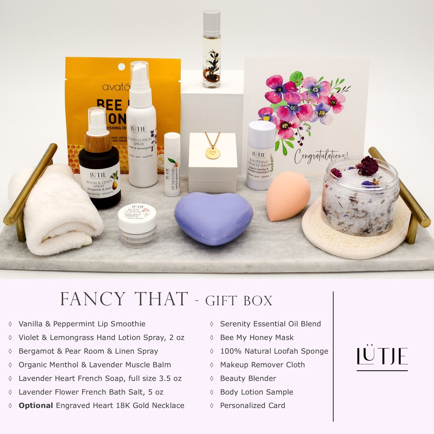 Fancy That Gift Box for women, BFF, wife, daughter, sister, mom, or grandma, includes Violet & Lemongrass hand lotion spray, essential oil, lip balm, soothing muscle balm, Bergamot & Pear room & linen spray, French soap, French bath salts, hydrating face mask, other bath, spa and self-care items, and optional 18K gold-plated necklace with engraved heart.