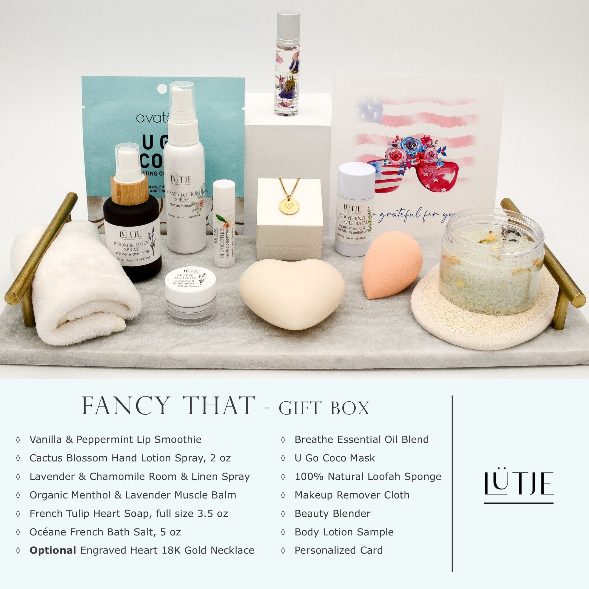 Fancy That Gift Box for women, BFF, wife, daughter, sister, mom, or grandma, includes Cactus Blossom hand lotion spray, essential oil, lip balm, soothing muscle balm, Lavender & Chamomile room & linen spray, French soap, French bath salts, hydrating face mask, other bath, spa and self-care items, and 18K gold-plated necklace with engraved heart.